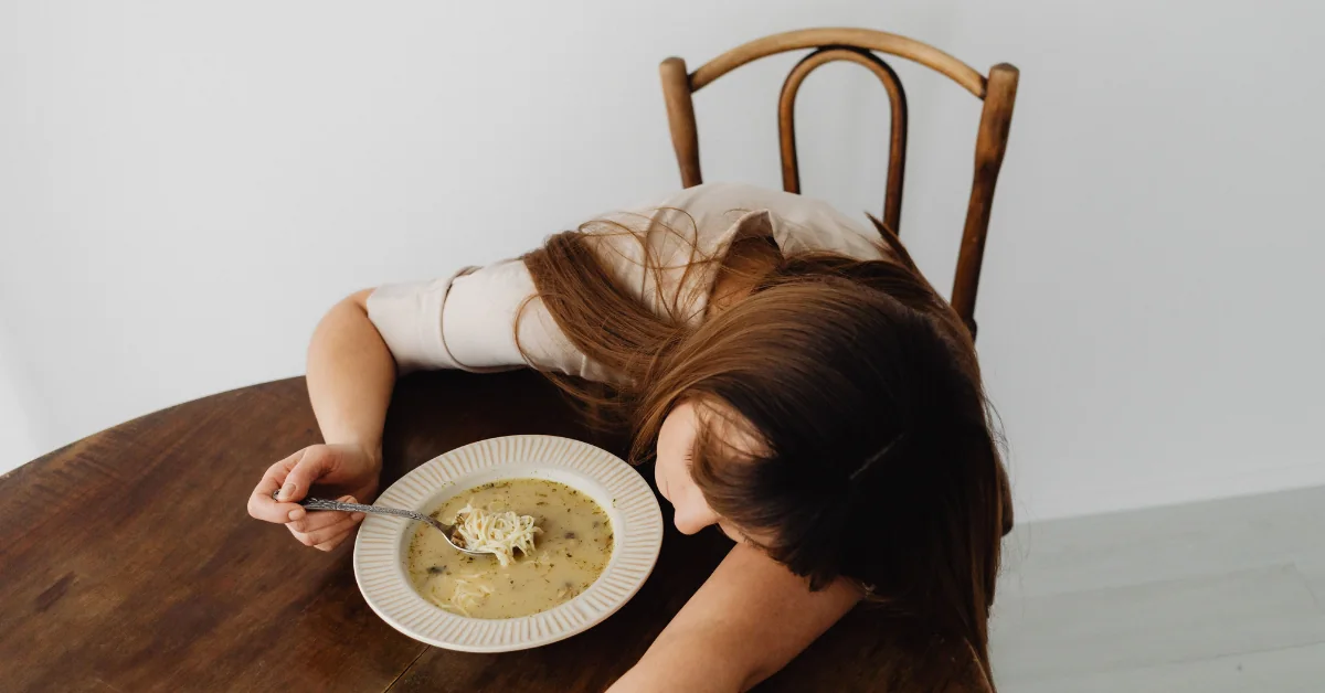 Person experiencing fatigue related to celiac disease and gluten sensitivity after a meal