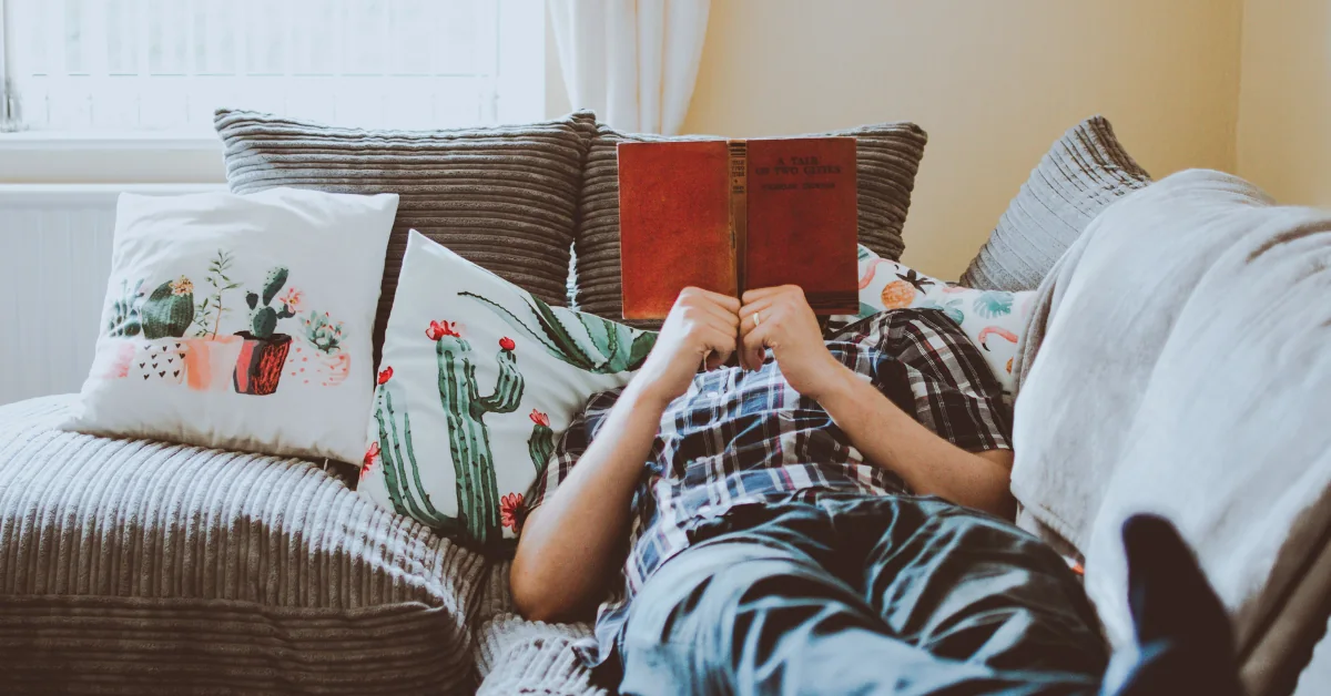 Person resting on a couch mid-afternoon, glass of water nearby