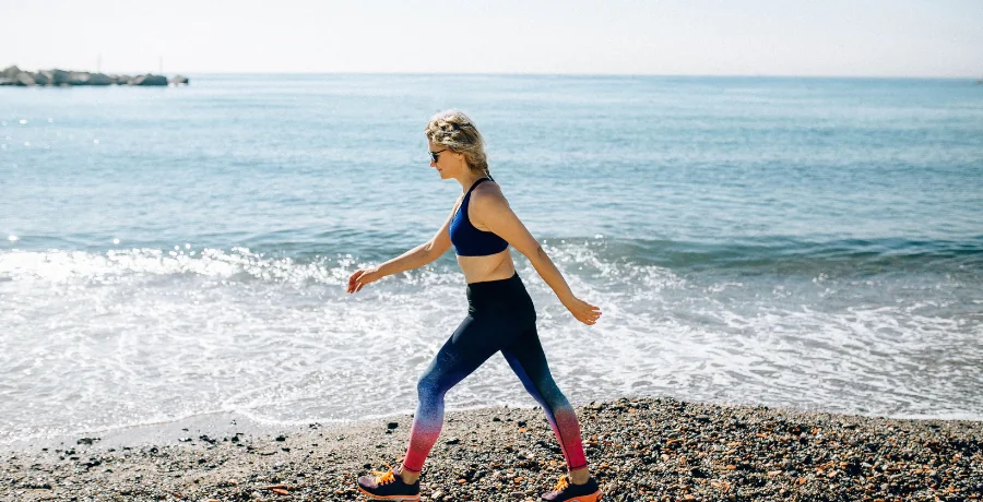 Person walking briskly outdoors, casual activewear, midday