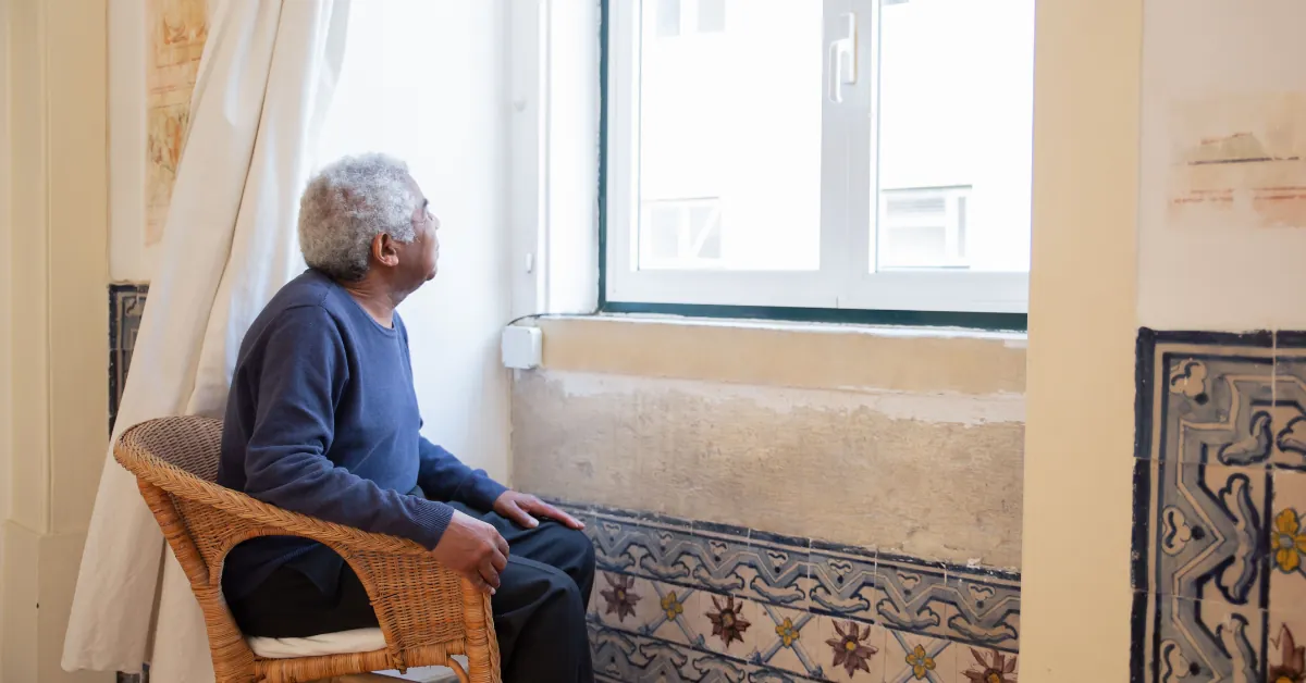 Older adult resting calmly by a window, soft daylight