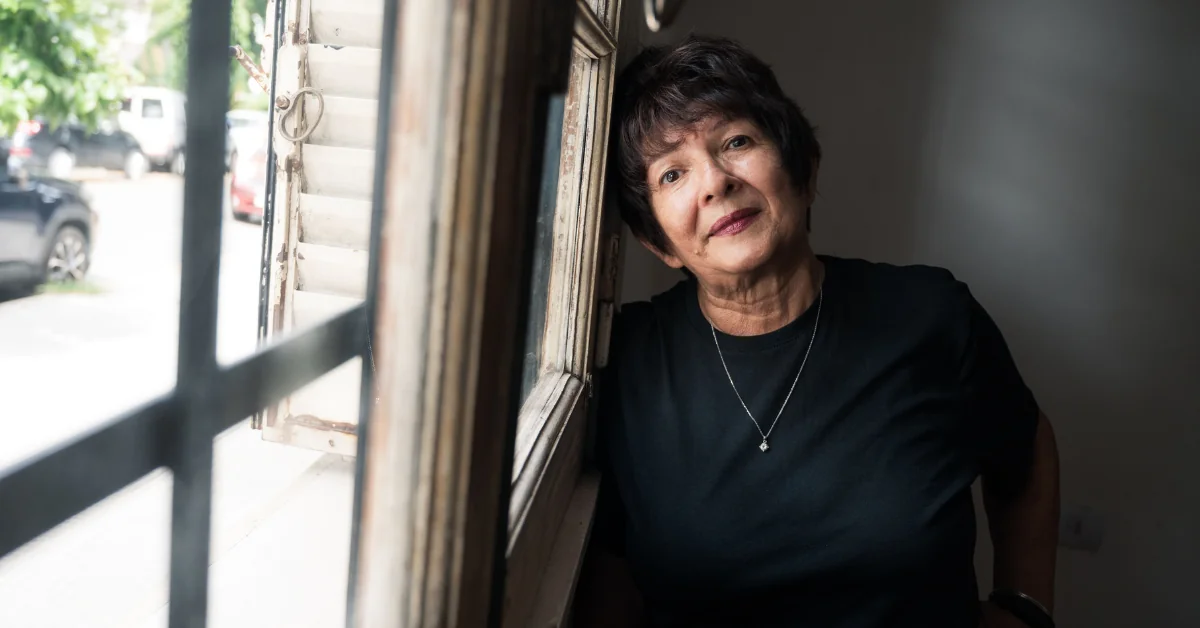 An older adult sitting calmly near a window with soft daylight creating a peaceful and comfortable atmosphere.