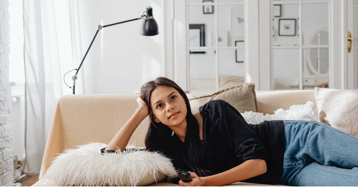A person resting on a couch mid-afternoon, natural light, dignified and calm