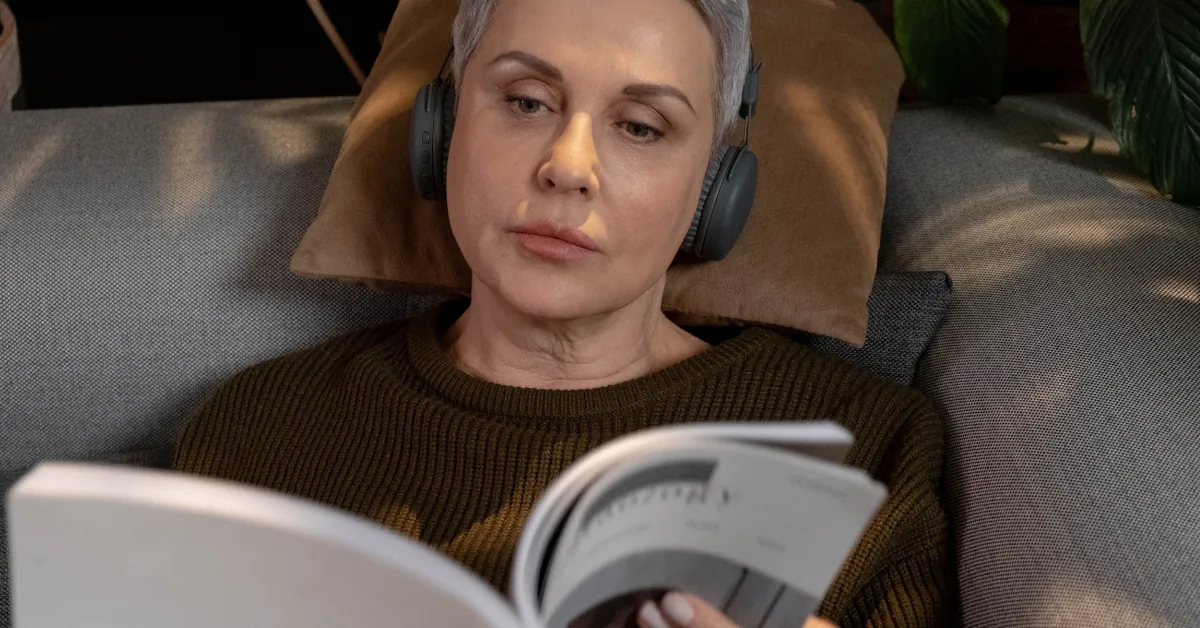 Middle-aged woman resting on a sofa at home with fatigue symptoms in soft natural light