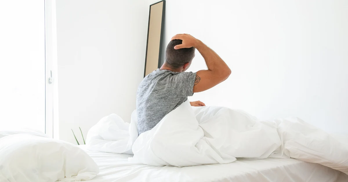 Person waking up with morning stiffness and fatigue associated with ankylosing spondylitis