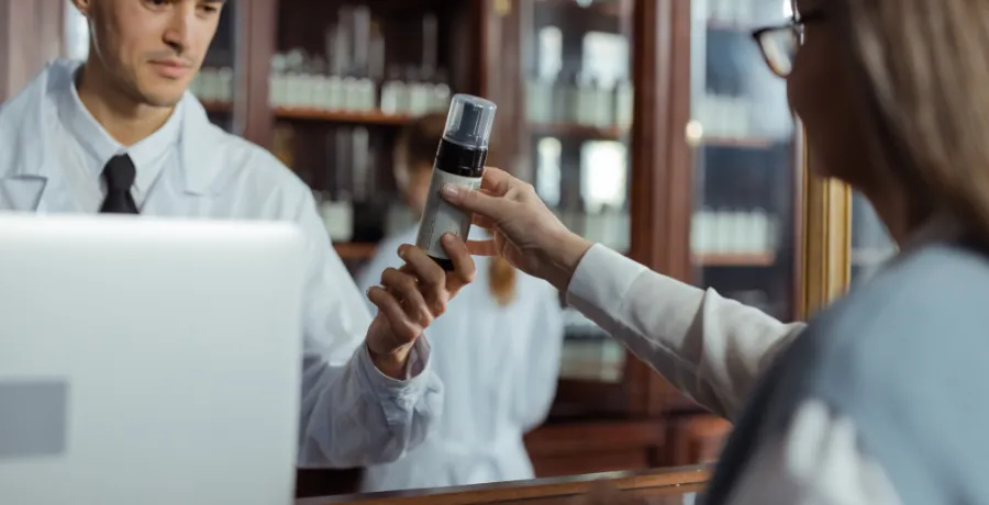 Pharmacist reviewing a medication list with a patient at the counter
