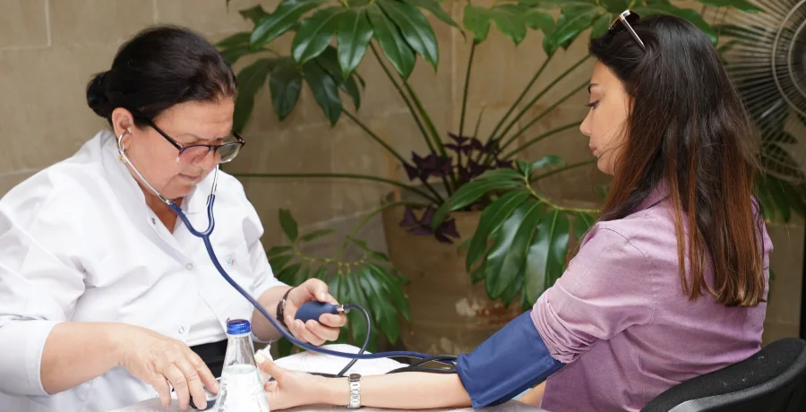 Midwife taking a pregnant patient's blood pressure at a prenatal visit